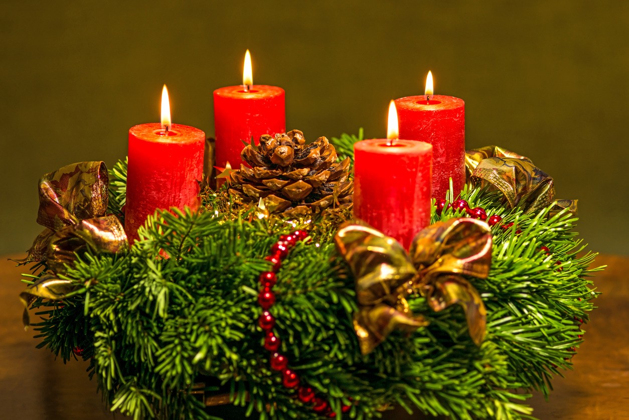 Una pequeña corona de Navidad con velas rojas