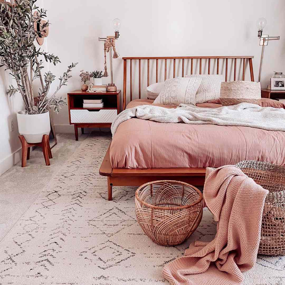 Un dormitorio boho con tonos rosas