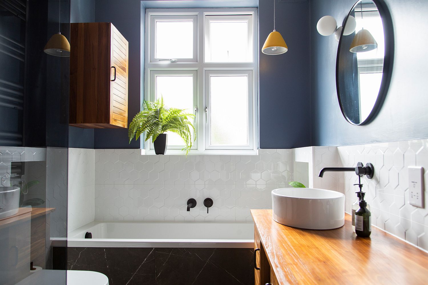 Un bagno grigio con decorazioni blu scuro